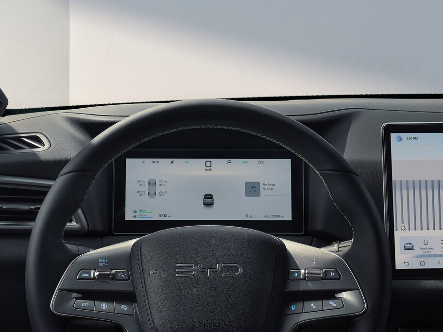 Blick auf das Lenkrad mit dem Schriftzug BYD und zwei digitale Anzeigen im Armaturenbrett eines Fahrzeugs