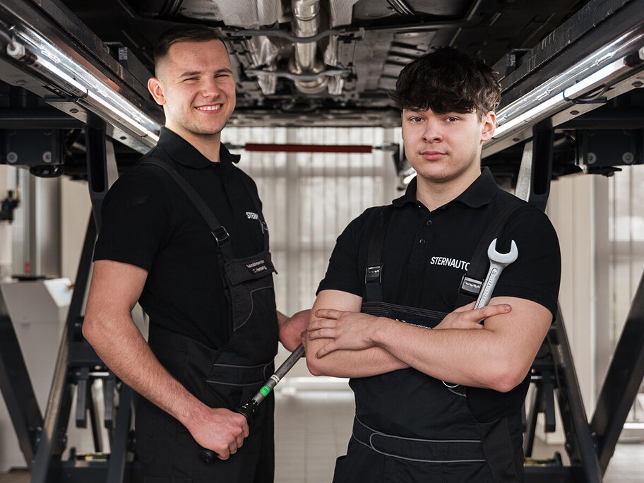 Kfz-Mechaniker stehen unter Fahrzeug