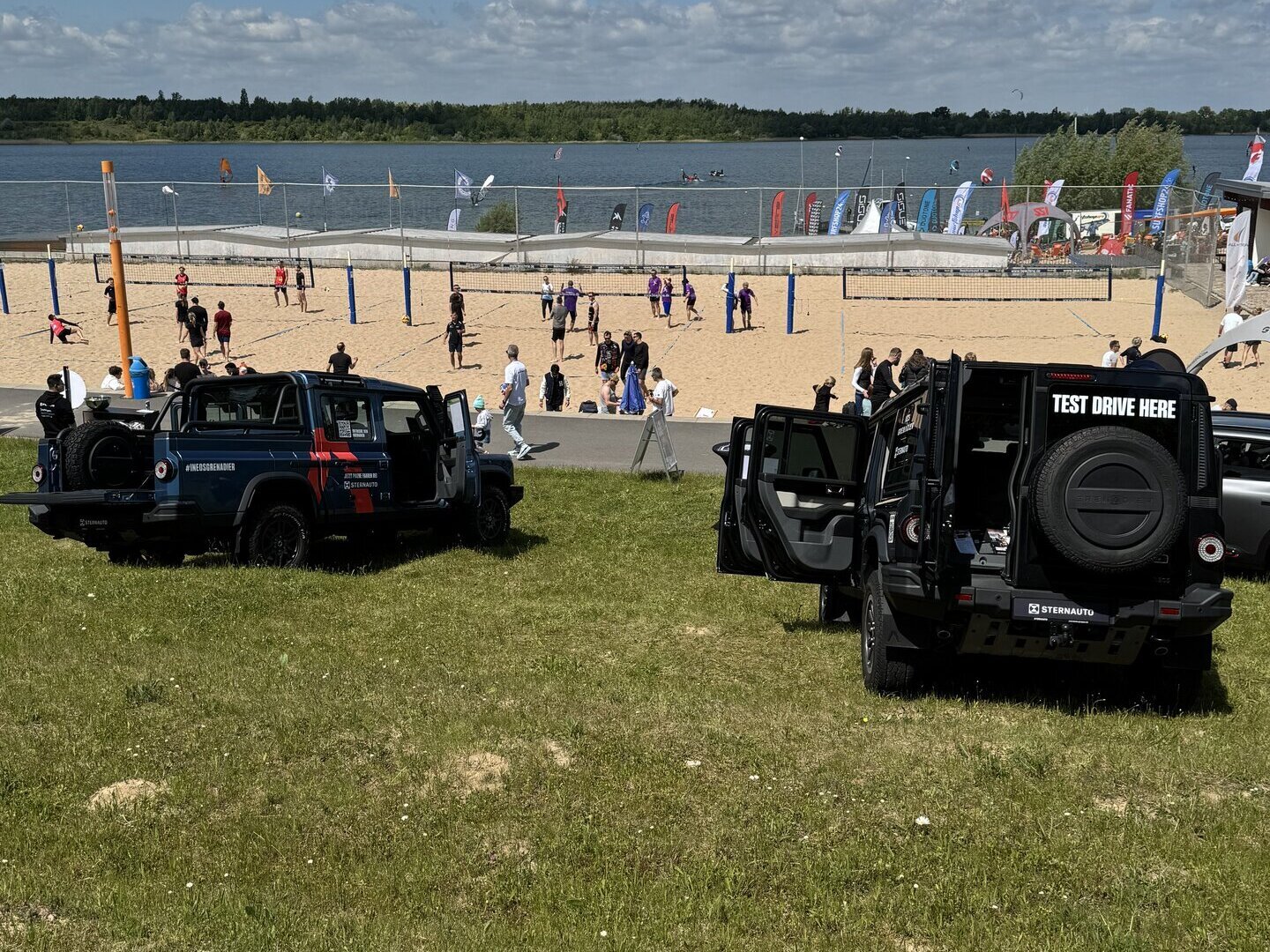 Zwei INEOS Grenadier vor einem See und Strand