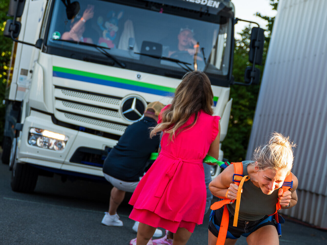 Frauen und Männer beim Truck-Ziehen