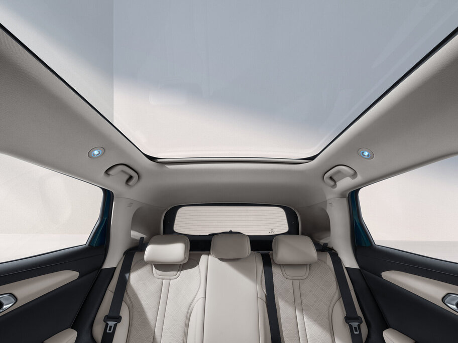 Innenraum eines Fahrzeugs mit hellem Dachhimmel und großem Panoramadach