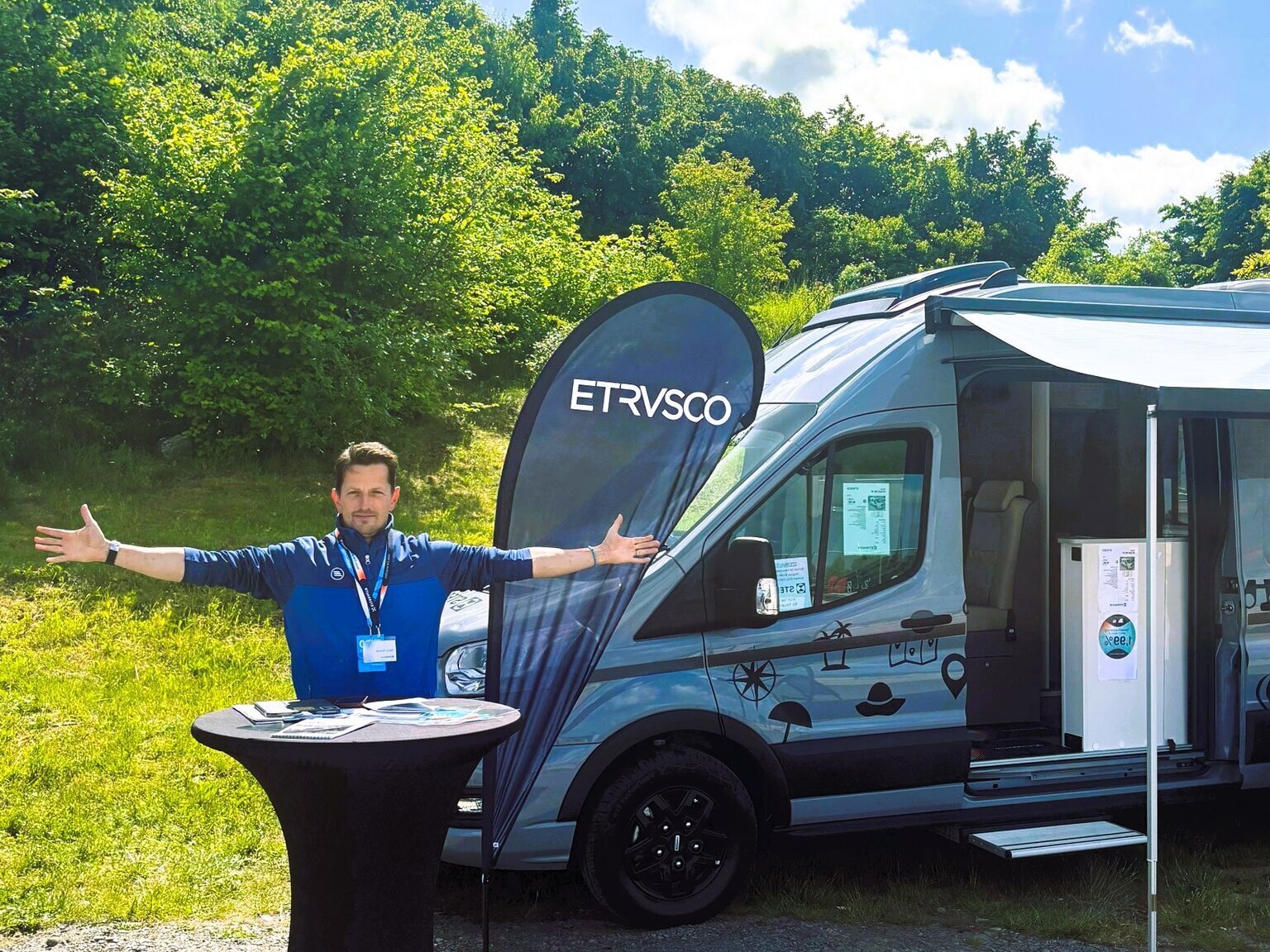 Heiko draußen vor einem Hymer Wohnmobil mit ausgestreckten Armen