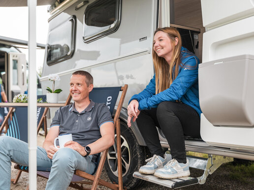 Mitarbeiter vor Campingvan, Urlaubssituation