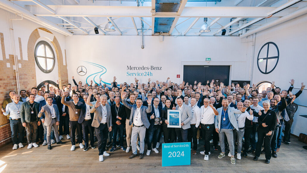 Eine Gruppe von Menschen jubeln und stehen hinter einem Schild mit der Aufschrift "Best of Service24h 2024"