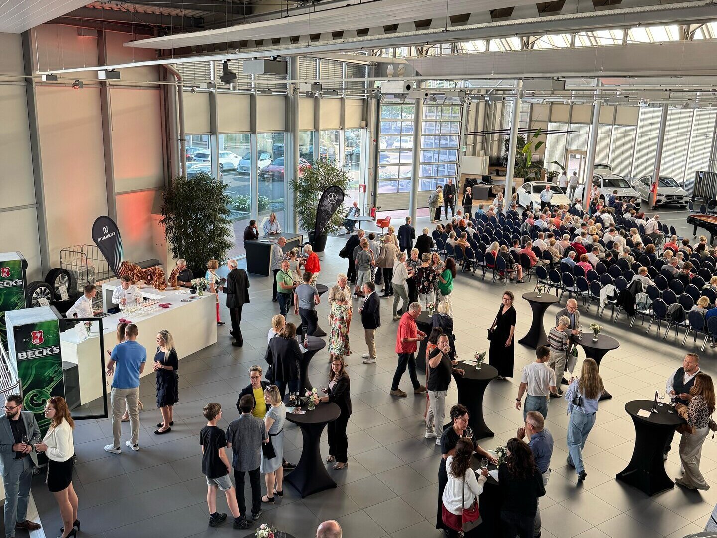 Ein Blick von oben auf das Event - Menschen stehen an Stehtischen und trinken
