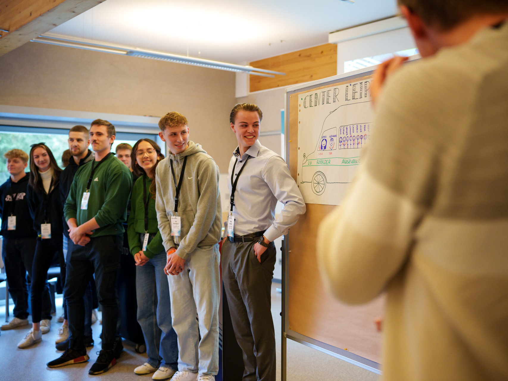 Eine Gruppe von Menschen steht um ein Whiteboard und diskutiert Ideen
