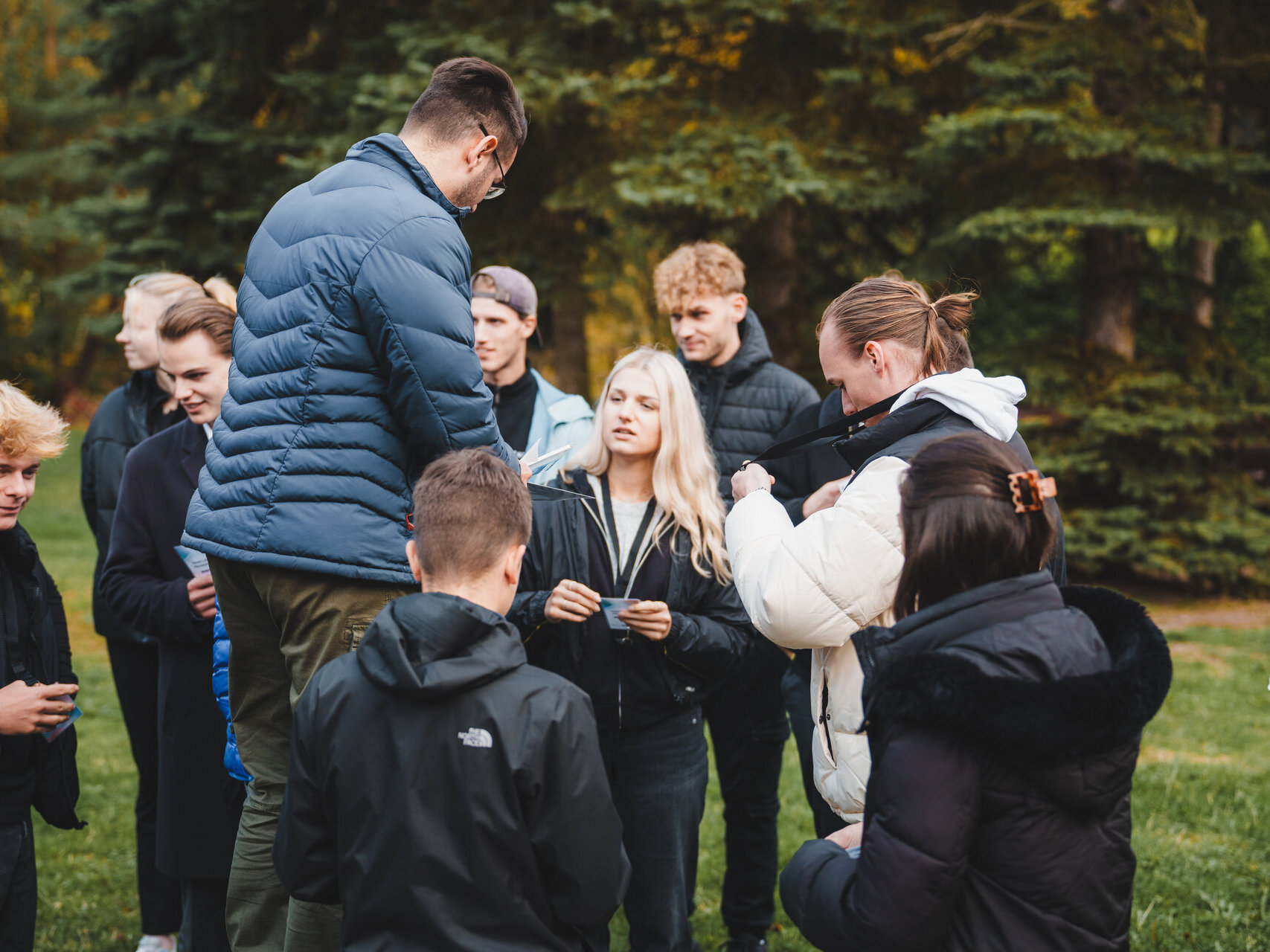 Eine Gruppe von Menschen steht um einen Mann in einem Park