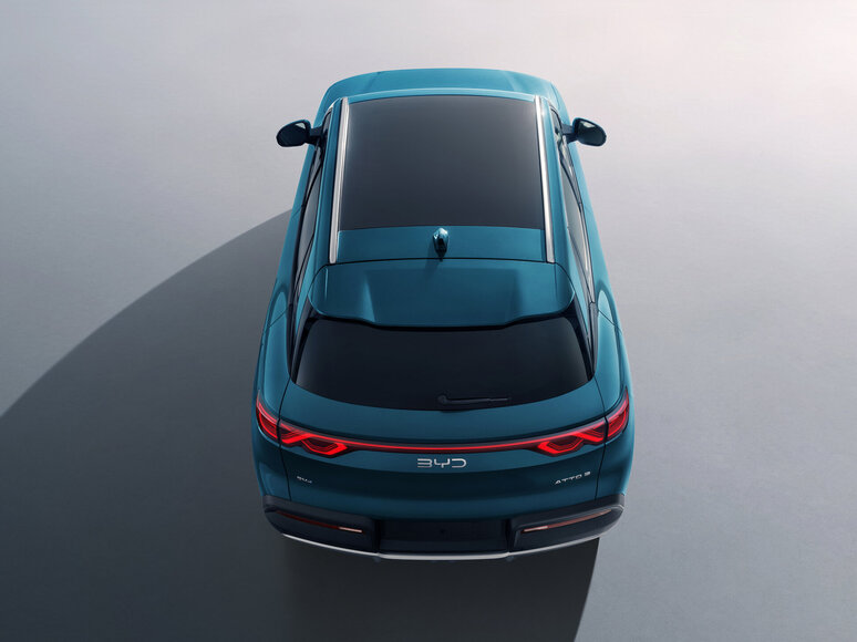 Draufsicht auf ein blaues Auto mit schwarzem Glasdach und roten Rückleuchten