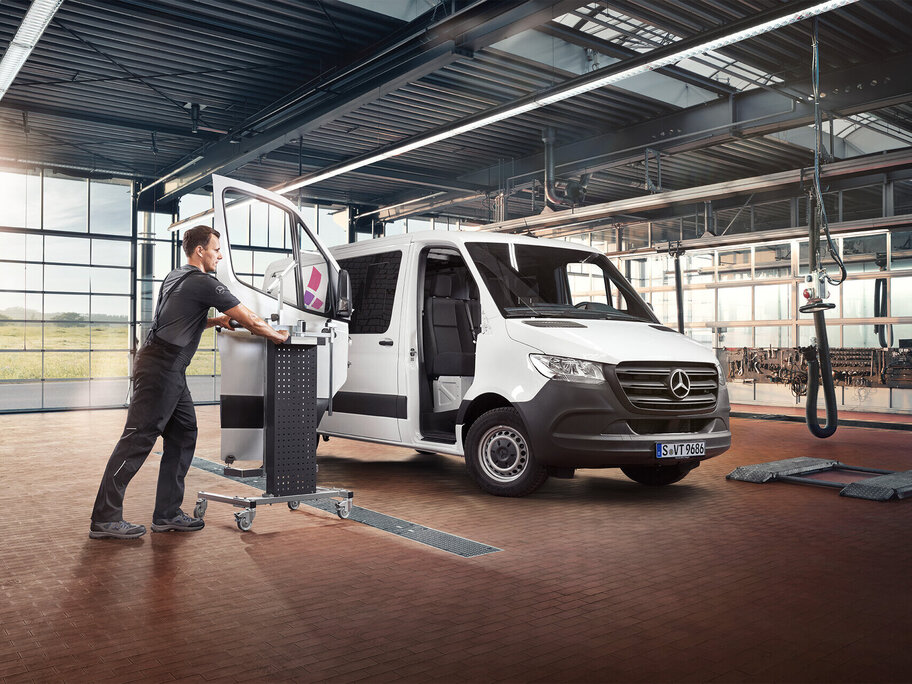 Mechaniker baut Tür in Transporter ein