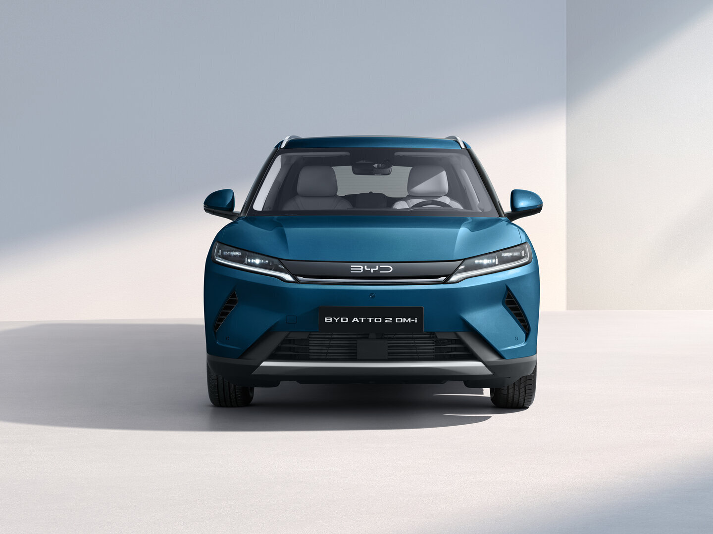 Frontansicht eines blauen BYD ATTO 2 DM-i Elektroautos vor weißem Hintergrund