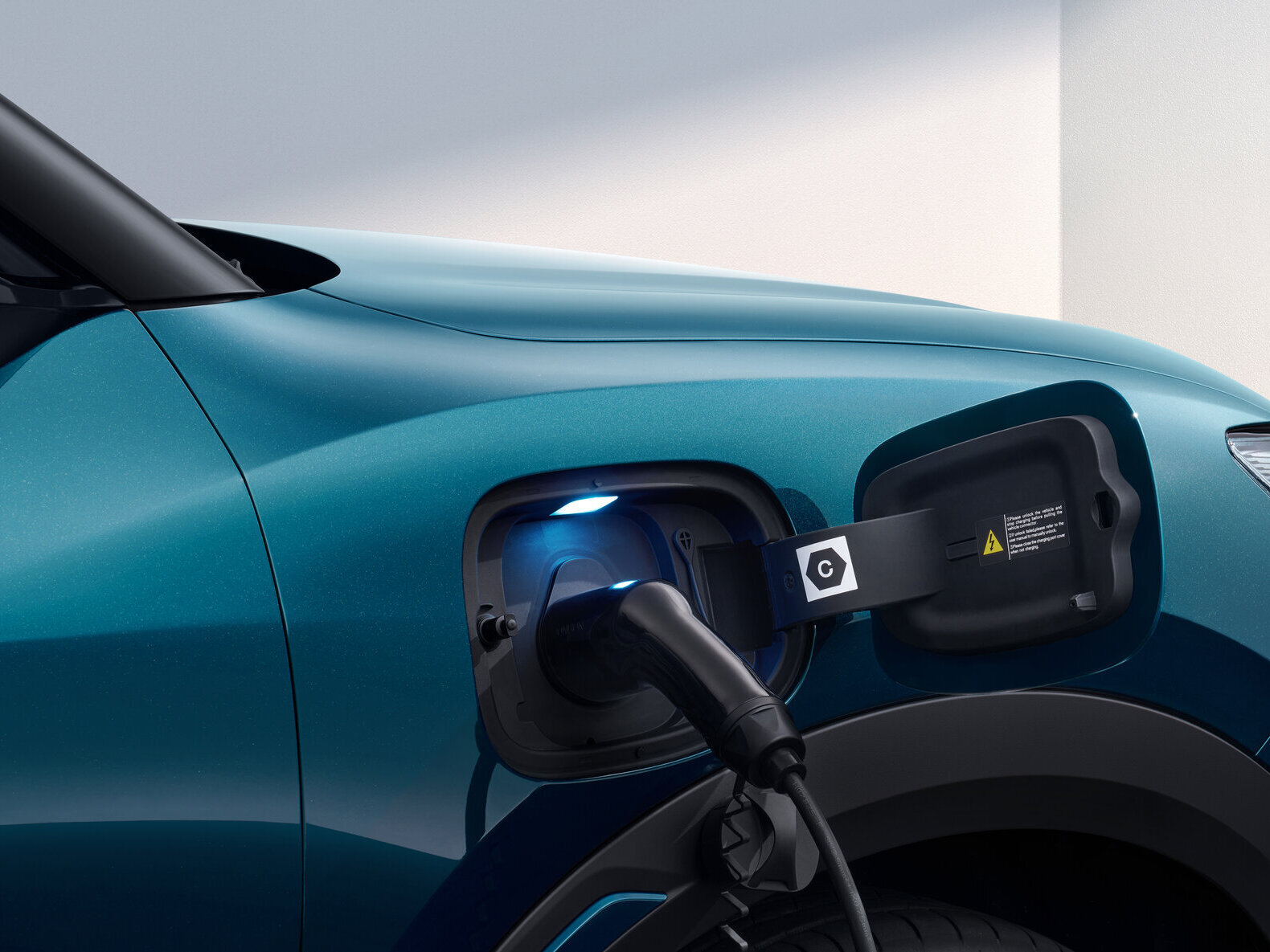 Elektroauto mit Ladestecker an der vorderen linken Seite angeschlossen