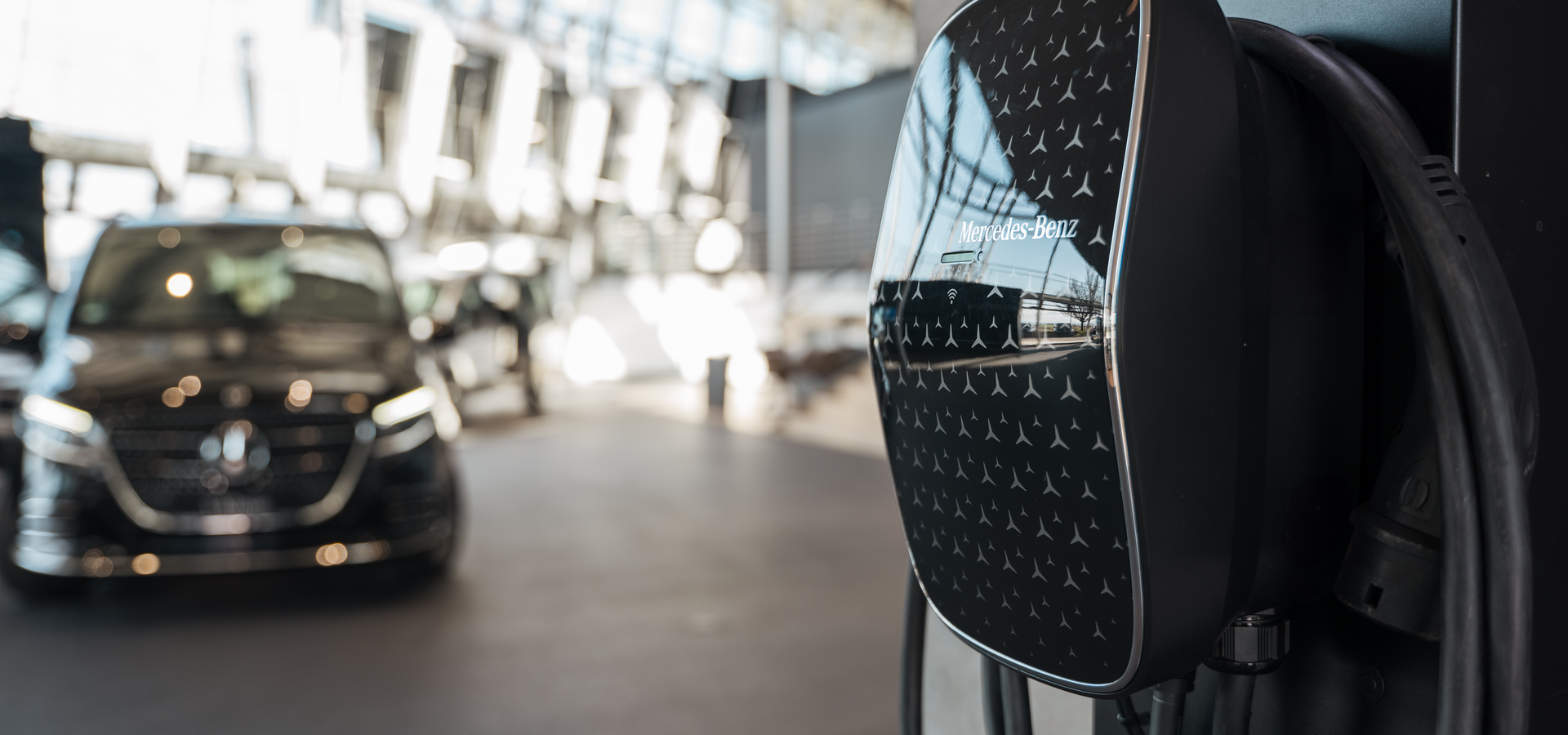 Im Vordergrund eine Mercedes-Benz Wallbox im Hintergrund ein MB Elektrovan