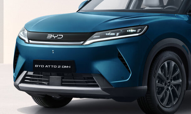 Blauer BYD ATTO 2 DM-i SUV steht in einem hellen, minimalistischen Raum mit Schatten an der Wand