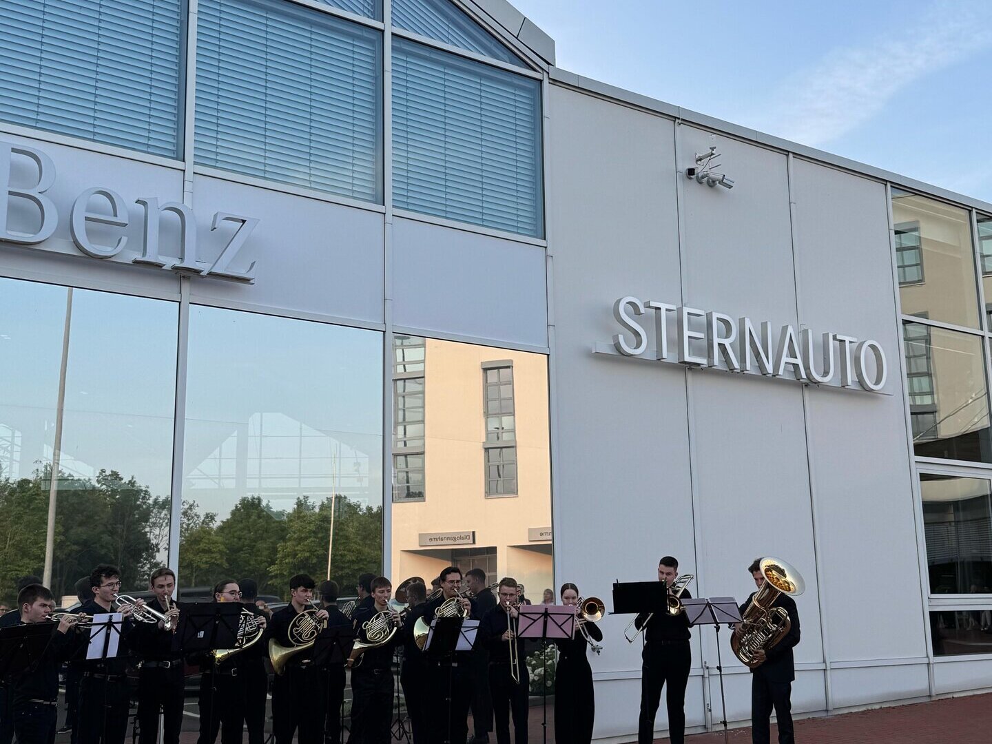 Vor dem Autohaus STERNAUTO steht ein Orchester mit Instumenten